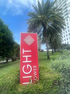 a red sign in front of a palm tree at The Light Arena Ocean Tower in Cam Ranh International Airport