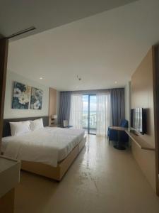 a hotel room with a bed and a television at The Light Arena Ocean Tower in Cam Ranh International Airport
