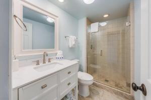 a bathroom with a sink and a toilet and a shower at Menehune Shores 403 · MHS 403 Remodeled BeachFront 2BD Getaway in Kihei +43 photos