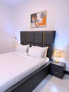 a bedroom with a large bed with a black headboard at Mody Haven in Kampala