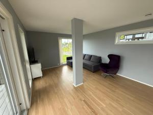 ein Wohnzimmer mit einer Couch und einem Sessel in der Unterkunft Luksuriøs enebolig, nær Ålesund in Ytterland