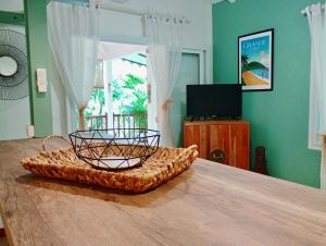 a basket on top of a table in a room at Gîtes Atemoya. Petit Bas Vent Fort Royal. in Deshaies