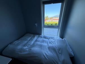 ein Bett in einem Zimmer mit Fenster in der Unterkunft Luksuriøs enebolig, nær Ålesund in Ytterland