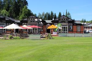a large building with tables and umbrellas in front of it at Apartmán Sofie Mariánské Lázně in Mariánské Lázně