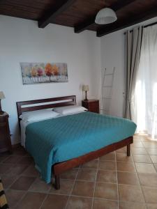 a bedroom with a bed with a blue comforter at Villa Marini in Trevignano Romano