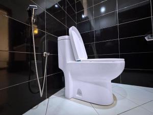 a white toilet in a bathroom with a shower at Mody Haven in Kampala +27 photos