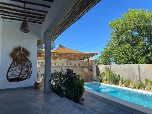 a villa with a swimming pool and a house at Aloe House in Matemwe