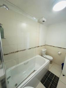 グラスゴーにあるMaster Bedroom in City Centerのバスルーム(シャワー、トイレ、バスタブ付)