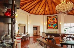 a dining room with tables and a chandelier at Cottage 43 in Nuwara Eliya +1 photo