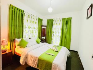 a bedroom with green curtains and a bed at Cottage 43 in Nuwara Eliya