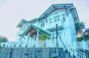 a large white house with a white fence at Cottage 43 in Nuwara Eliya