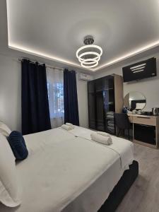 a bedroom with a large white bed and a desk at Villa Kristin Residence in Monfalcone