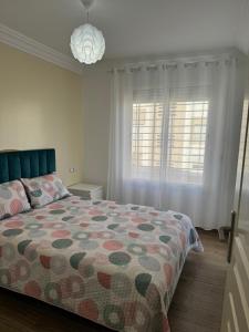 ein Schlafzimmer mit einem Bett und zwei Fenstern in der Unterkunft Blue Ocean Escape Sidi Rhal in Sidi Rahal + 5 Fotos