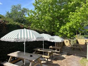 two picnic tables with umbrellas on a patio at The Eight Bells Inn, Bolney in Bolney