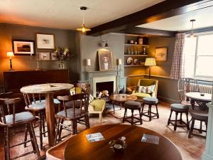 a room with tables and chairs and a fireplace at The Eight Bells Inn, Bolney in Bolney