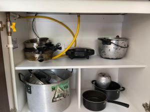 a shelf with pots and pans in a kitchen at Apartamento en clima caliente in Apulo