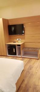 a hotel room with a bed and a flat screen tv at Hotel Relax in Jāmb