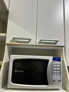 a microwave oven in a kitchen with white cabinets at Rio Stay- Copacabana in Rio de Janeiro