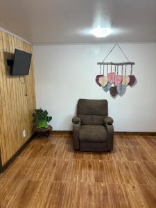 a living room with a chair and a television at ruta de los parques in Chile Chico