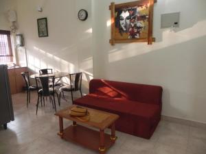 Una sala de estar con un sofá rojo y una mesa. en Tropical VIBES RETREAT, en Calangute
