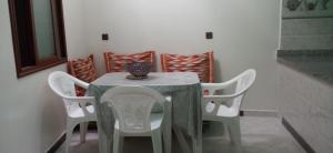 a table with white chairs and a vase on it at شقة في موقع سياحي لمحبي المناظر الخلابة وشلالات in Beni Mellal +4 photos