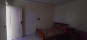 a bedroom with a bed in a room with a door at شقة في موقع سياحي لمحبي المناظر الخلابة وشلالات in Beni Mellal