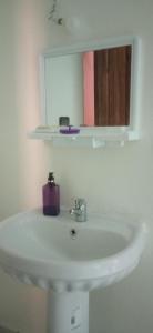 a bathroom sink with a mirror and a purple soap at شقة في موقع سياحي لمحبي المناظر الخلابة وشلالات in Beni Mellal
