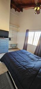 a bedroom with a blue bed and a window at Ribera Calma in Los Reartes