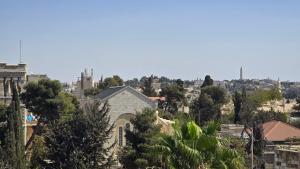 a view of a city with trees and buildings at St Thomas Home's Guesthouse - Jerusalem in Jerusalem