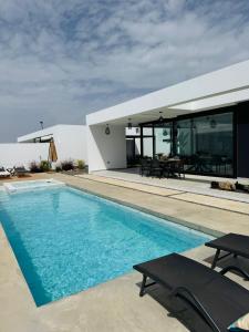 a swimming pool in front of a house at Stylish and comfortable Villa Anna in Villaverde in Lajares