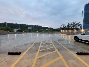 a parking lot with a white car parked in it at Hotel PIED Suseong in Daegu
