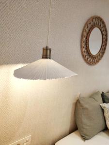 Una lámpara blanca colgada de una pared con un espejo. en Apartamento-loft - Rincón de Belén, en Jaén