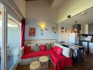 sala de estar con sofá y almohadas rojas en T3 Duplex avec Terrasse, Piscine et Parking à Vieux-Boucau - FR-1-379-115, en Vieux-Boucau-les-Bains