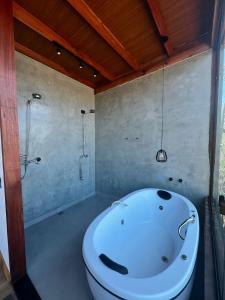 a bathroom with a white tub and a shower at Reserva Cipó in Serra do Cipo +42 photos