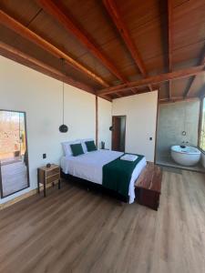 a bedroom with a bed and a bath tub and a bed sidx sidx sidx at Reserva Cipó in Serra do Cipo