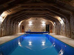 una piscina cubierta en un edificio con una pared de piedra en Maison d'hôte - Les Fayards, en Montregard