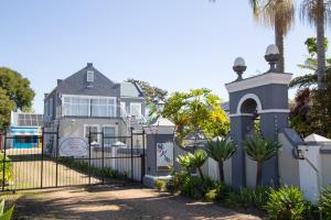 a house with a gate and a fence at Tsitsikamma Mountain View Lodge in Stormsrivier
