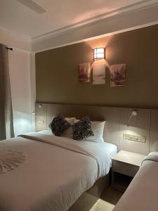 a bedroom with a white bed with a light on it at The G Ten Holiday Inn in Hulhumale