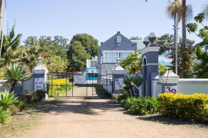 a driveway with a gate in front of a house at Tsitsikamma Mountain View Lodge in Stormsrivier