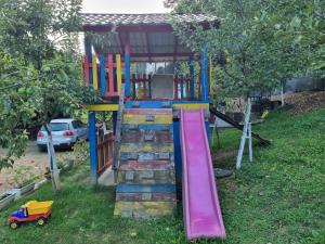 a colorful playground with a slide in a yard at Dolina Mira in Srebrenik