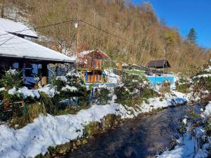 a house in the snow next to a river at Dolina Mira in Srebrenik