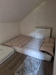 a bedroom with two beds and a rug at Dolina Mira in Srebrenik