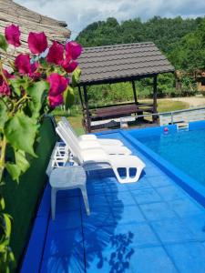 a pool with two chairs and a gazebo at Dolina Mira in Srebrenik +23 photos