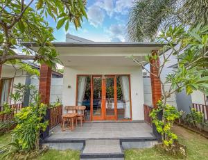 a home with an orange door and a patio at Singabu Bungalows in Nusa Penida
