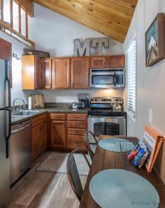 a kitchen with wooden cabinets and a table with chairs at Escape To Ptarmigan Village 9 in Whitefish