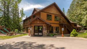 a wooden house with a picnic table in front of it at Escape To Ptarmigan Village 9 in Whitefish