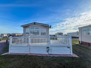 a white fence with a gate in the grass at Ref 40035Nd - Superb Caravan With Decking & Free Wifi At North Denes Holiday Park in Lowestoft