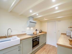 una cocina con fregadero y estufa horno superior en Dyserth, en Clynnog-fawr