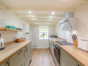 cocina con armarios blancos y suelo de madera en Dyserth, en Clynnog-fawr 12 fotos más
