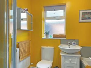 a bathroom with a toilet and a sink and a window at Pinecote in Bottesford +5 photos